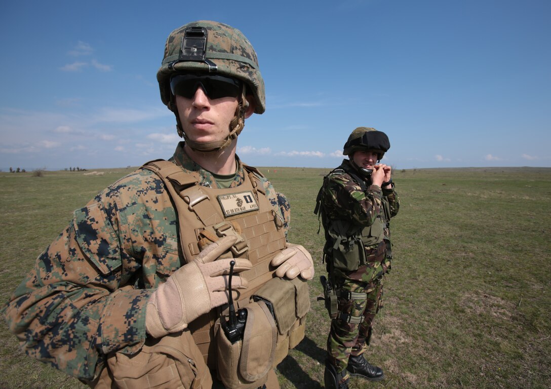 Captain Bryan Phillips, Executive Officer, Weapons Company, 3rd Battalion, 8th Marines, assigned to Black Sea Rotational Force 14 and Captain Claudia Visan, company commander, Romanian 307th Naval Infantry,  look downrange during a combined maneuver live fire exercise at Babadag Training Area, Romania, 26 March, 2014.  Romanian service members and Marines from BSRF-14 integrated fire teams during the live fire exercise.  Black Sea Rotational Force 14 is a task force of Marines and sailors with the mission to sustain positive relationships with partner nations uphold regional stability and increase military operational capabilities while also proving the ability for rapid crisis response in the Black Sea, Balkan and Caucasus regions of Eastern Europe. (Official Marine Corps photo by Staff Sgt. Tanner M. Iskra, BSRF Combat Camera/Released)