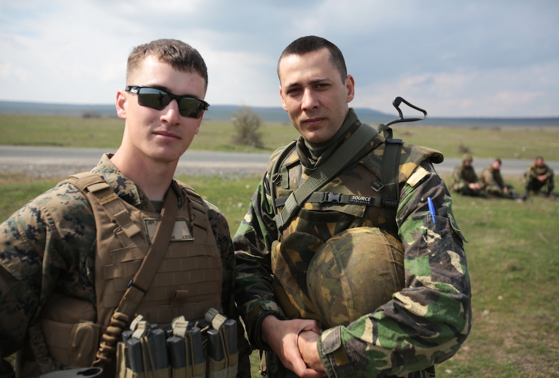 Corporal Christopher Hipp, mortarman, Weapons Company, 3rd Battalion, 8th Marines, assigned to Black Sea Rotational Force 14 poses with Corporal Dumi Iulian, Romanian 307th Naval Infantry Battalion during a combined maneuver live fire exercise at Babadag Training Area, Romania, 26 March, 2014.  Romanian service members and Marines from BSRF-14 integrated fire teams during the live fire exercise.  Black Sea Rotational Force 14 is a task force of Marines and sailors with the mission to sustain positive relationships with partner nations uphold regional stability and increase military operational capabilities while also proving the ability for rapid crisis response in the Black Sea, Balkan and Caucasus regions of Eastern Europe. (Official Marine Corps photo by Staff Sgt. Tanner M. Iskra, BSRF Combat Camera/Released)