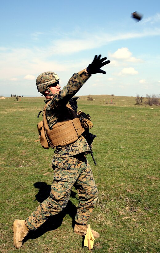 Corporal Marcus Thibodeau, an infantryman with Weapons Company, 3rd Battalion, 8th Marine Regiment, 2nd Marine Division assigned to Black Sea Rotational Force 14, throws a notional grenade during a live-fire exercise with Romanian service members of 307th Naval Infantry Bn. aboard Babadag Training Area in Romania March 26, 2014. Black Sea Rotational Force 14 is a contingent of Marines and sailors tasked with maintaining positive relations with partner nations, regional stability and increasing interoperability while providing the capability for rapid crisis response, as directed by U.S. European Command, in the Black Sea, Balkan and Caucasus regions of Eastern Europe. (Official Marine Corps photo by Lance Cpl. Scott W. Whiting, BSRF PAO/ Released)