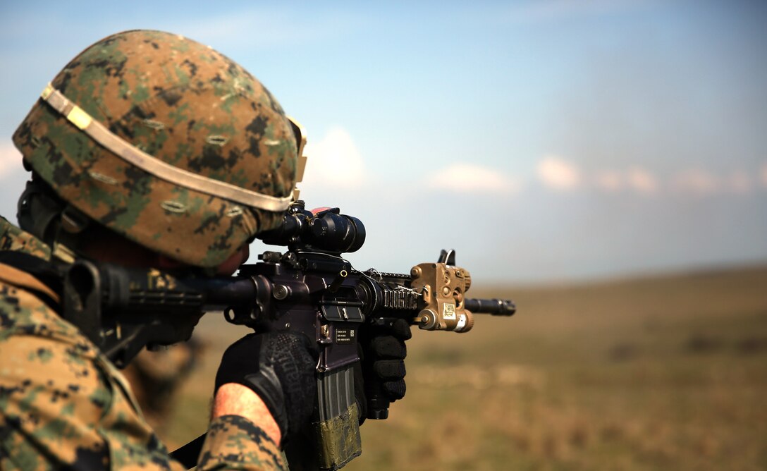 Corporal Marcus Thibodeau, an infantryman with Weapons Company, 3rd Battalion, 8th Marine Regiment, 2nd Marine Division assigned to Black Sea Rotational Force 14, fires his M4 rifle downrange at a target during a live-fire exercise aboard Babadag Training Area in Romania with Romanian service members from 307th Naval Infantry Bn. March 26, 2014. Black Sea Rotational Force 14 is a contingent of Marines and sailors tasked with maintaining positive relations with partner nations, regional stability and increasing interoperability while providing the capability for rapid crisis response, as directed by U.S. European Command, in the Black Sea, Balkan and Caucasus regions of Eastern Europe. (Official Marine Corps photo by Lance Cpl. Scott W. Whiting, BSRF PAO/ Released)