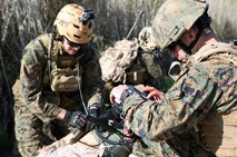 While HM2 Kristofer Baskett (left) assesses the Sailor’s simulated wounds, Sgt. Danny Pereira (right) monitors his vital signs with the Tempus Pro portable vital signs monitor. Pereira was able to transmit the vital signs as well as pictures and video of the injuries back to the Battalion Aid Station through the Tempus Pro.