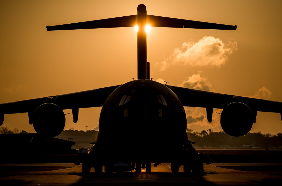 The sun rises above a C-17 Globemaster III assigned to the 437th Airlift Wing March 24, 2014, at Joint Base Charleston, S.C. The first C-17 to enter the Air Force’s inventory arrived at Charleston Air Force Base in June 1993. The C-17 is capable of rapid strategic delivery of troops and all types of cargo to main operating bases or directly to forward bases in the deployment area. (U.S. Air Force photo/Senior Airman Dennis Sloan)