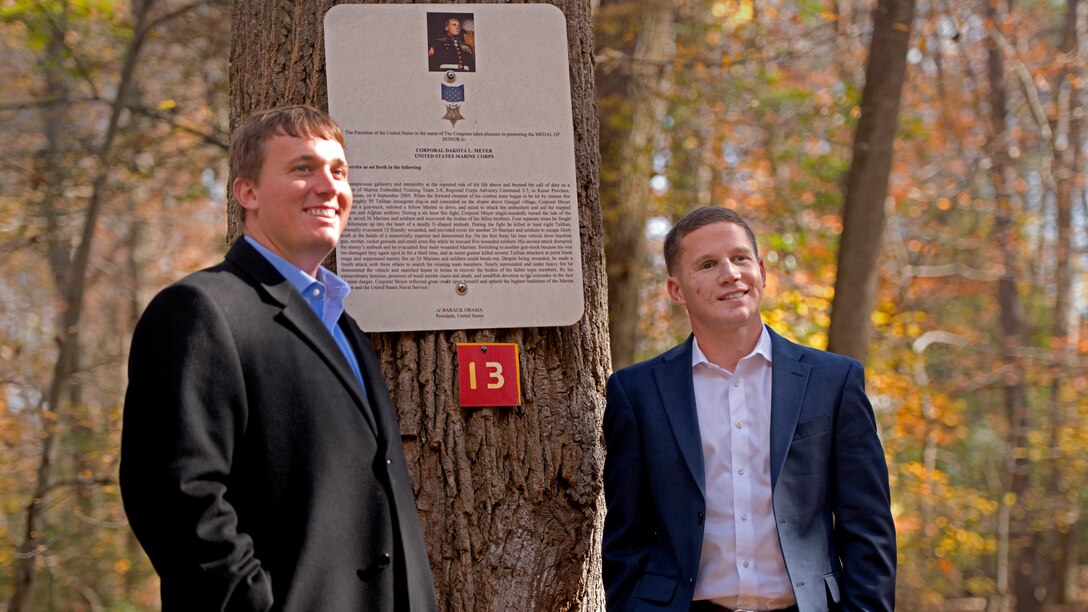 Sgt. Dakota Meyer and Cpl. Kyle Carpenter stand in front of a plaque describing the events for which Meyer received the Medal of Honor on a trail at Officer Candidate School in Quantico, Va., Nov. 8, 2013. Meyer, a Medal of Honor recipient, and Cpl. Kyle Carpenter, a Purple Heart recipient, traveled to different units and barracks in the National Capital Region to speak with and motivate junior Marines. Meyer will be the guest of honor for the Commandant's Birthday Ball on Nov. 9, 2013. (U.S. Marine Corps photo by Pfc. Eric T. Keenan/Released)
