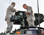 Maj. Gen. Lawrence Nicholson (right), commanding general of 1st Marine Division, Camp Pendleton, Calif., and Gunnery Sgt. Thomas Jensen, Marine Corps Forces Pacific, inspect the anti-tank weapon system of a Light Armored Vehicle Anti-Tank prototype between developmental tests at the Amphibious Vehicle Test Branch. LAV-ATs are in the midst of developmental tests as part of their modernization program at various sites throughout the country. 