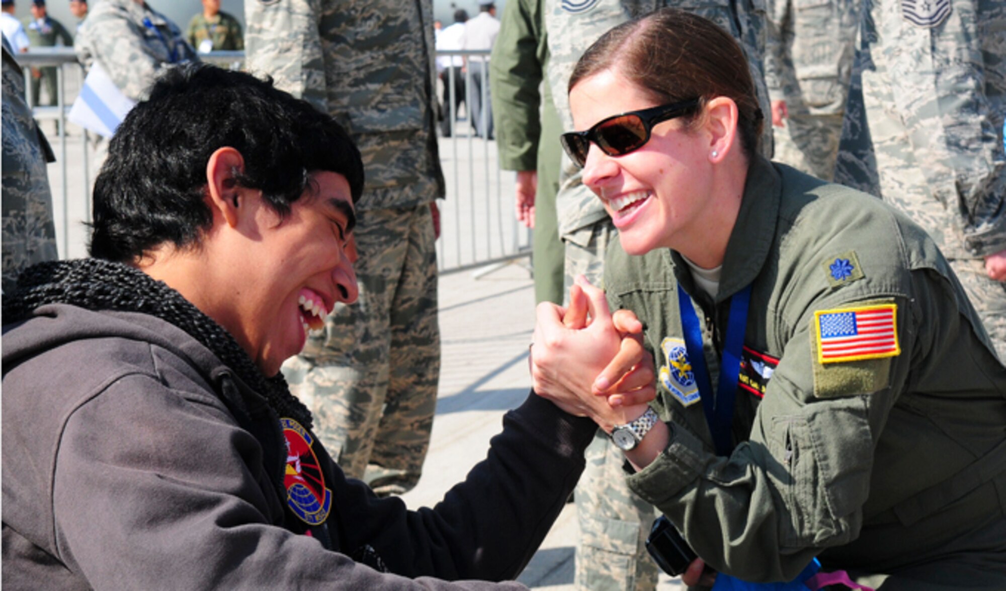 Lt. Col. Kat Callaghan spends time with a Chilean boy from the Teletón Foundation at the FIDAE Air Show in Santiago, Chile, March 26. Nearly 60 Airmen participate in subject matter expert exchanges with Chilean air force counterparts during FIDAE, and as part of the events are hosting static displays of the C-130 Hercules and F-16. Airmen from the Texas Air National Guard set aside time to host the children before the public days of FIDAE, which are scheduled for the weekend. Callaghan is the 571st Mobility Support Advisory Squadron director of operations. (U.S. Air Force photo/Senior Master Sgt. Miguel Arellano)