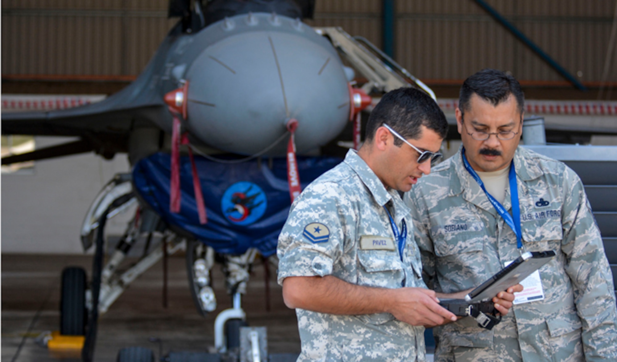 Master Sgt. Pedro Soriano talks with a counterpart from the Chilean air force about working with the F-16 Fighting Falcon during the first day of the FIDAE Air Show, March 25, 2014, in Santiago, Chile. Nearly 60 Airmen are participating in subject matter expert exchanges with Chilean air force counterparts during FIDAE,  sharing best practices and procedures to build partnerships and promote interoperability with partner-nations throughout South America, Central America and the Caribbean. Soriano is an F-16 maintenance specialist from the Texas Air National Guard. (U.S. Air Force photo/Capt. Justin Brockhoff)
