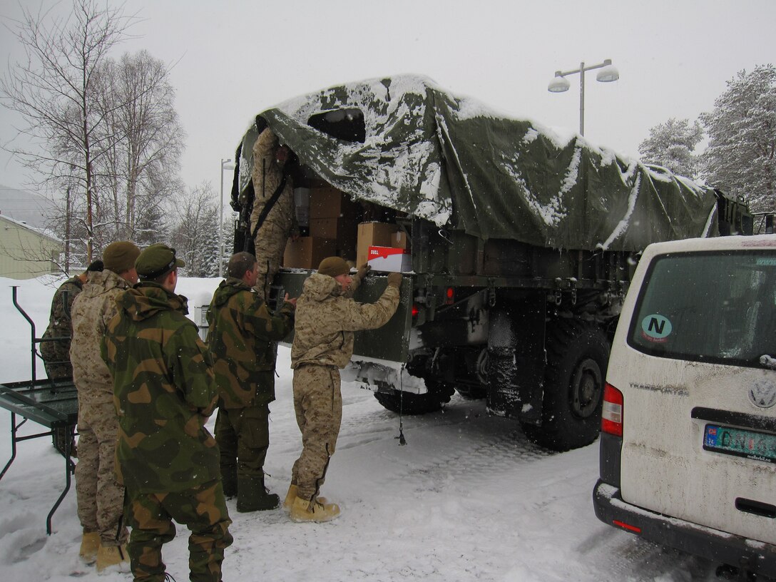 Food service specialists with 2nd Supply Battalion, Combat Logistics Regiment 25, 2nd Marine Logistics Group and soldiers with Host Nation Support Battalion unload food for a battalion of British Royal Marines during Cold Response 2014 at Maalselv, Norway, March 15, 2014. 2nd Supply Bn. and HNSB integrated forces to provide support for 2nd Battalion, 2nd Marine Regiment, 2nd Marine Division and partner nations during the exercise. Cold Response 14 is a Norwegian-led multinational exercise above the Arctic Circle designed prepare for high-intensity cold-weather operations with nearly 16,000 troops from 16 different countries.                                