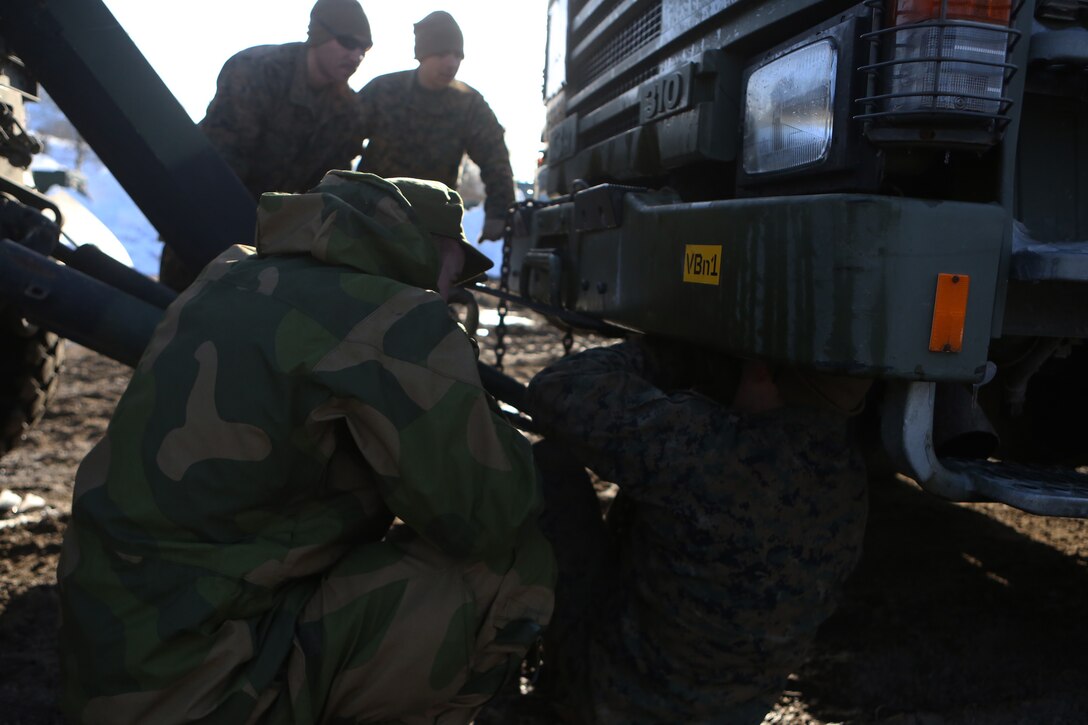 Marines with 2nd Supply Battalion, Combat Logistics Regiment 25, 2nd Marine Logistics Group and a soldier with Host Nation Support Battalion attach an HNSB truck to a 2nd Supply Bn.  during Cold Response 2014 at Elvegaardsmoen, Norway, March 15, 2014. The joint training gave service members an opportunity to improve international relations and interoperability between United States and Norwegian medical personnel. 