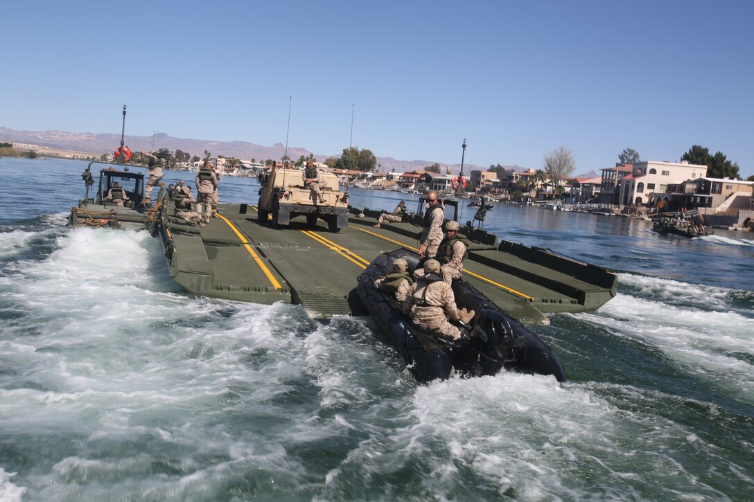 Marines with Bridge Company, 7th Engineer Support Battalion, 1st Marine Logistics Group, push an Improved Ribbon Bridge against the current of the Colorado River during a rafting exercise aboard Laughlin, Nev., March 17-21, 2014. More than 60 Marines trained in moving heavy equipment, to include 7-tons and Humvees, across a flowing body of water using BEBs and an Improved Ribbon Bridge. The IRB is a multi-piece floating bridge that can function as a raft. The BEBs were used to push the raft against the current. Despite being accustomed to training in a bay with little to no current, these Marines managed to transport two 7-tons up the river at the same time.