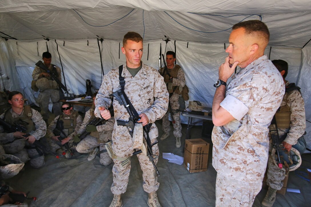 First Lt. Daniel English, company commander, Headquarters and Support Company, Combat Logistics Battalion 1, Combat Logistics Regiment 1, 1st Marine Logistics Group, talks with Brig. Gen. Vincent A. Coglianese, commanding general, 1st MLG, during Integrated Training Exercise 3-14 aboard Marine Corps Air Ground Combat Center Twenty-nine Palms, Calif., March 21, 2014. The month-long ITX prepares the battalion for its role, as the logistics combat element, in the final combat deployment of Operation Enduring Freedom.