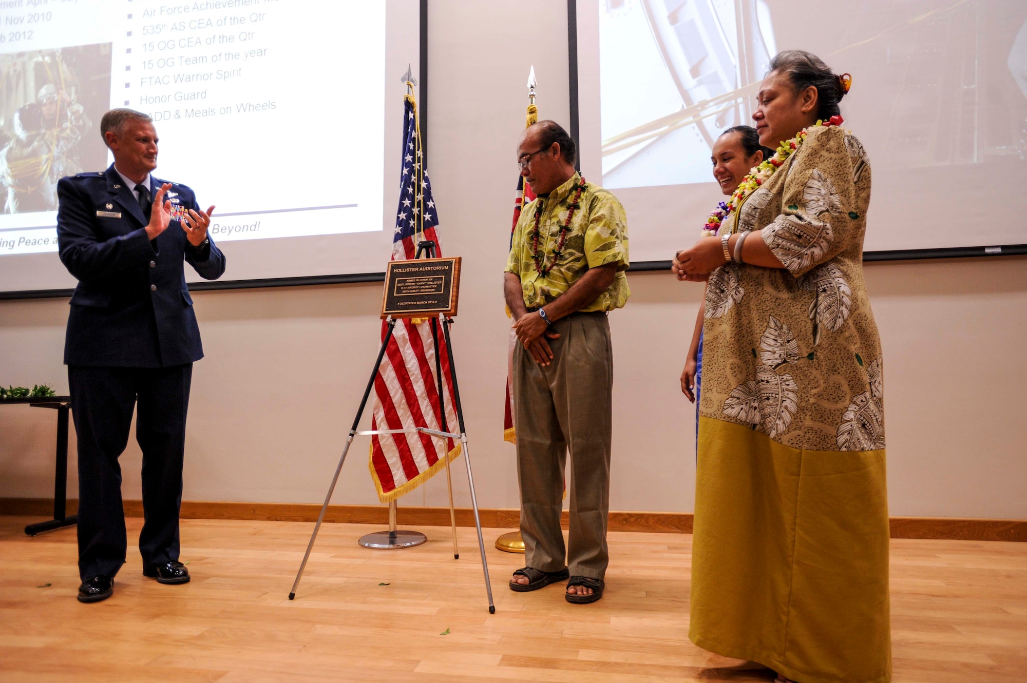 Lt. Col. Gregg Johnson, 535th Airlift Squadron commander (far left) applauds after unveiling a plaque with Tony Hollister (center), Toni-Marie Hollister, and Ann-Marie Hollister (far right) at the Hollister Auditorium on Joint Base Pearl Harbor-Hickam, Hawaii, March 28, 2014. The plaque will hang outside the doors to the newly dedicated auditorium in tribute to fallen comrade Staff Sgt. Robert “Danny” Hollister, who was a 535th AS loadmaster here. (U.S. Air Force photo/Tech. Sgt. Terri Paden)