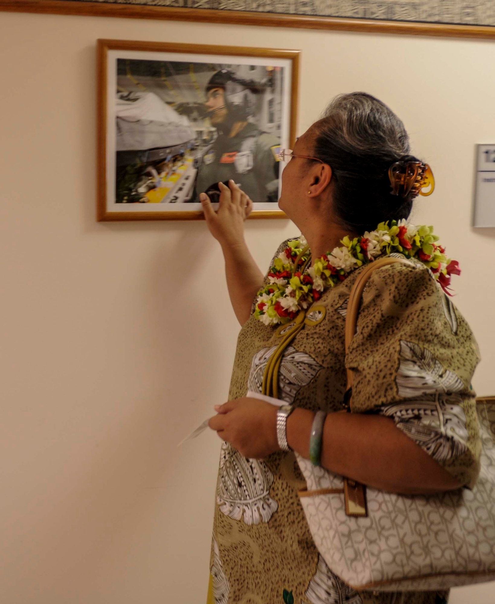 Ann-Marie Hollister, mom to fallen loadmaster Staff Sgt. Robert “Danny” Hollister, admires a picture of her son that hangs in a hallway at the C-17 Simulator building on Joint Base Pearl Harbor-Hickam, Hawaii, March 28, 2014. Ann-Marie visited JBPHH with husband, Tony Hollister and daughter, Toni-Marie Hollister, to attend the 535th Auditorium rededication ceremony, which renamed the room the Hollister Auditorium, in memory of her late son. (U.S. Air Force photo/Tech. Sgt. Terri Paden)