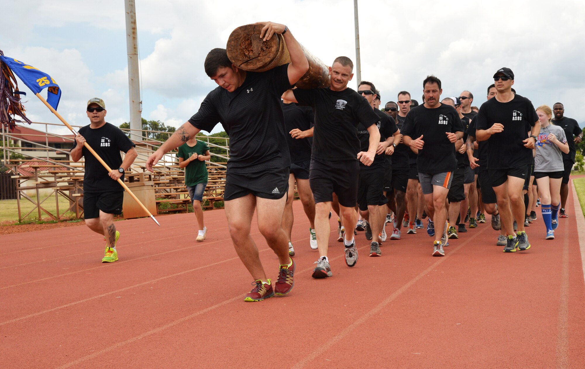 Members of the 25th Air Support Operations Squadron carry a log while other 25th ASOS Airmen run in formation during a 24-hour run challenge at Joint Base Pearl Harbor-Hickam, Hawaii, March 28, 2014. The annual challenge honors fallen TACP members, as well as raises money for the U.S. Air Force TACP Association. More than 3,100 miles were logged by 25th ASOS and base members between 12 p.m. March 27 through 11:59 a.m. March 28. (U.S. Air Force photo/Staff Sgt. Alexander Martinez)