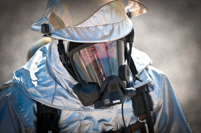 Carl Lambert, 99th Civil Engineer Squadron fire chief, awaits the beginning of his annual aircraft live fire exercise on the aircraft burn trainer March 27, 2014 at Nellis Air Force Base, Nev.  Nellis firefighters are required to complete the training exercise twice in daylight, and twice at night annually to stay flightline certified and ensure their preparedness to response rapidly to aircraft emergencies. (U.S. Air Force photo by Airman 1st Class Joshua Kleinholz)
