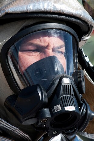 Carl Lambert, 99th Civil Engineering Squadron fire captain, prepares for live fire suppression training at the aircraft burn trainer March 27, 2014, at Nellis Air Force Base, Nev. Training sessions prepare Airmen for possible real world scenarios of aircraft catching fire on the flightline. (U.S. Air Force photo by Airman 1st Class Thomas Spangler)