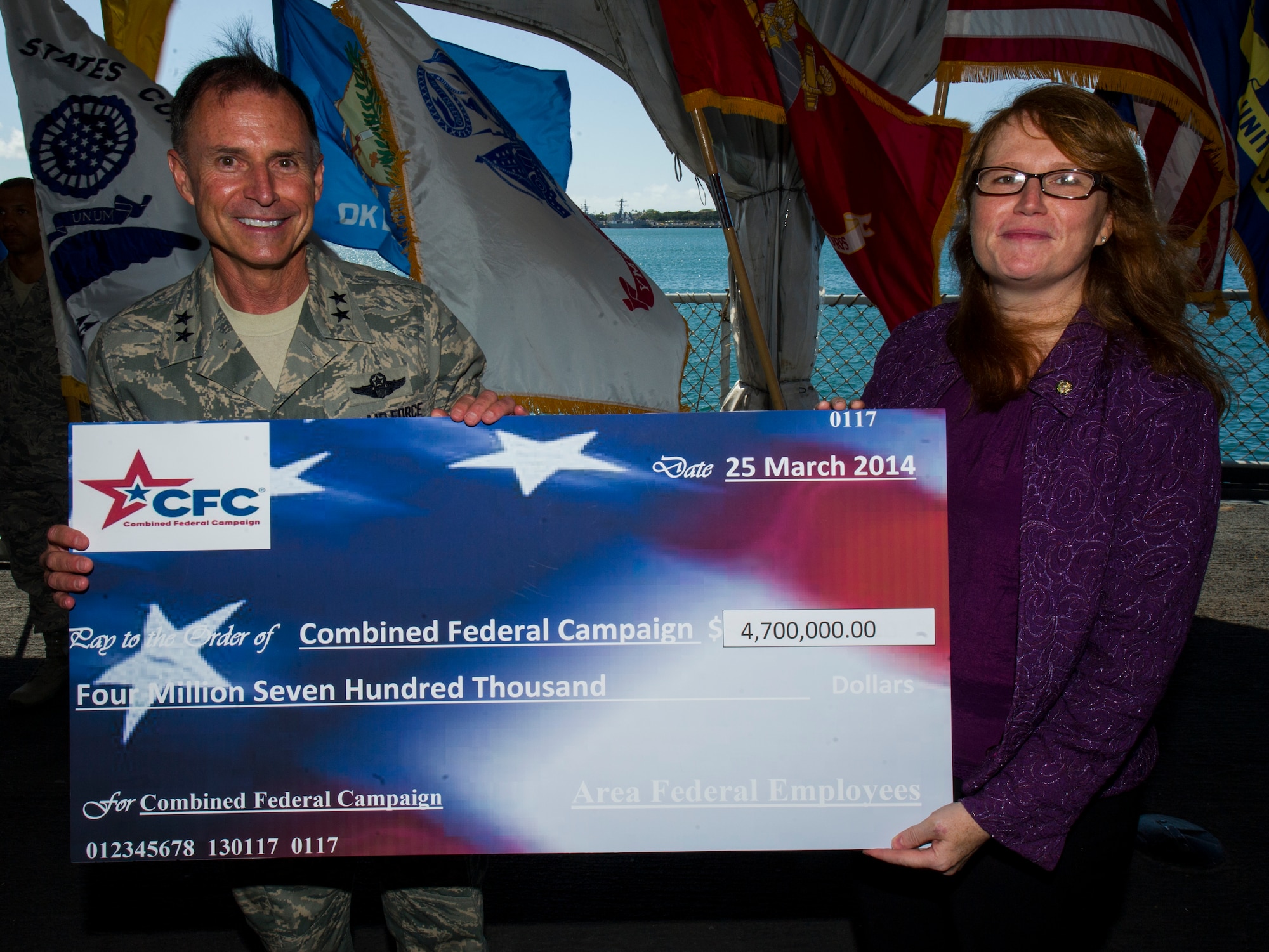 Maj. Gen. Kevin Pottinger, Mobilization Assistant to the Commander, Pacific Air Forces, presents the 2013 Combined Federal Campaign check to Colby Stanton, Honolulu-Pacific federal executive board chair, March 25, 2014, aboard the U.S.S. Missouri. Pacific Air Forces led the 2013 CFC, which raised more than $5 million in donations from government employees across the Hawaii-Pacific area. (U.S. Air Force photo by Staff Sgt. Nathan Allen)