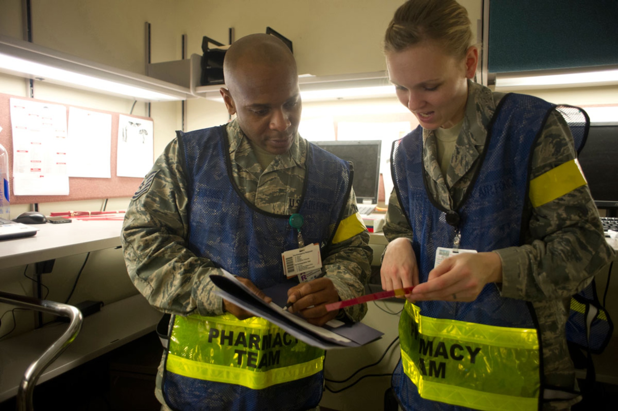 JOINT BASE ELMENDORF–RICHARDSON, Alaska--Pharmacy technicians Tech. Sgt. Robert Banks and Senior Airman Hannah Fronapfel, 673d Medical Group, discuss medication distribution for simulated earthquake casualties at Joint Base Elmendorf-Richardson, Alaska, March 27, 2014, during JBER's Mission Assurance Exercise 14-3. MAE 14-3 is a JBER exercise testing the base’s ability to survive, operate and coordinate during a major natural disaster. (U.S. Air Force photo/Justin Connaher)