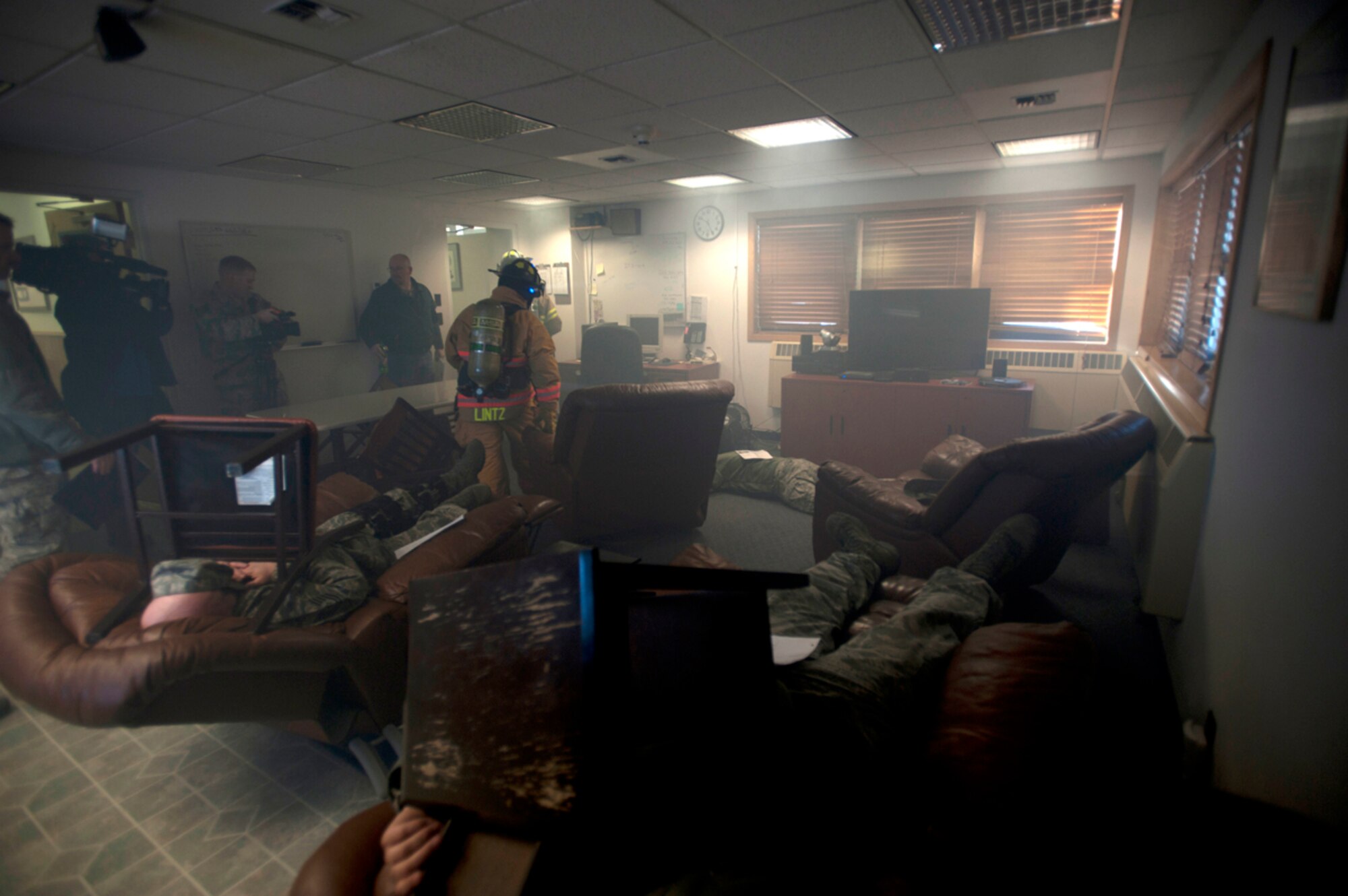 A KTVA cameraman, left, films as firefighters from the 673d Civil Engineer Squadron search for victims after a simulated earthquake during Joint Base Elmendorf-Richardson's Mission Assurance Exercise 14-3, part of the overall Alaska Shield disaster response preparedness and response exercise March 27, 2014. MAE 14-3 is one of many exercises for Alaska Shield. AK Shield is a statewide exercise that tests local, state and federal cooperation at multiple venues throughout the state. (U.S. Air Force photo/Staff Sgt. Robert Barnett)