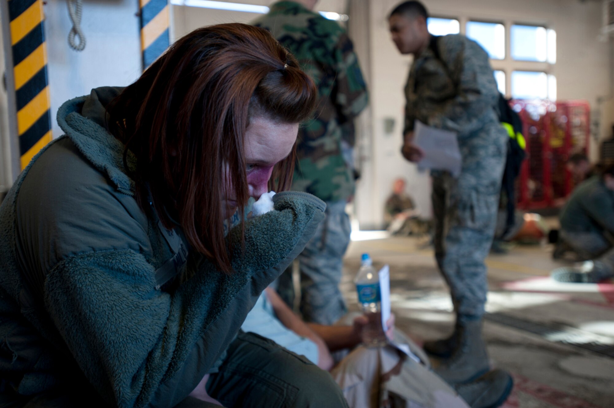Senior Airman Marlina Mills cares for her simulated broken nose in Fire Station 2 during a simulated earthquake emergency scenario during Joint Base Elmendorf-Richardson's Mission Assurance Exercise 14-3, part of the overall Alaska Shield disaster response preparedness and exercise March 27, 2014. MAE 14-3 is one of many exercises that fall under exercise Alaska Shield. (U.S. Air Force photo/Staff Sgt. Robert Barnett)