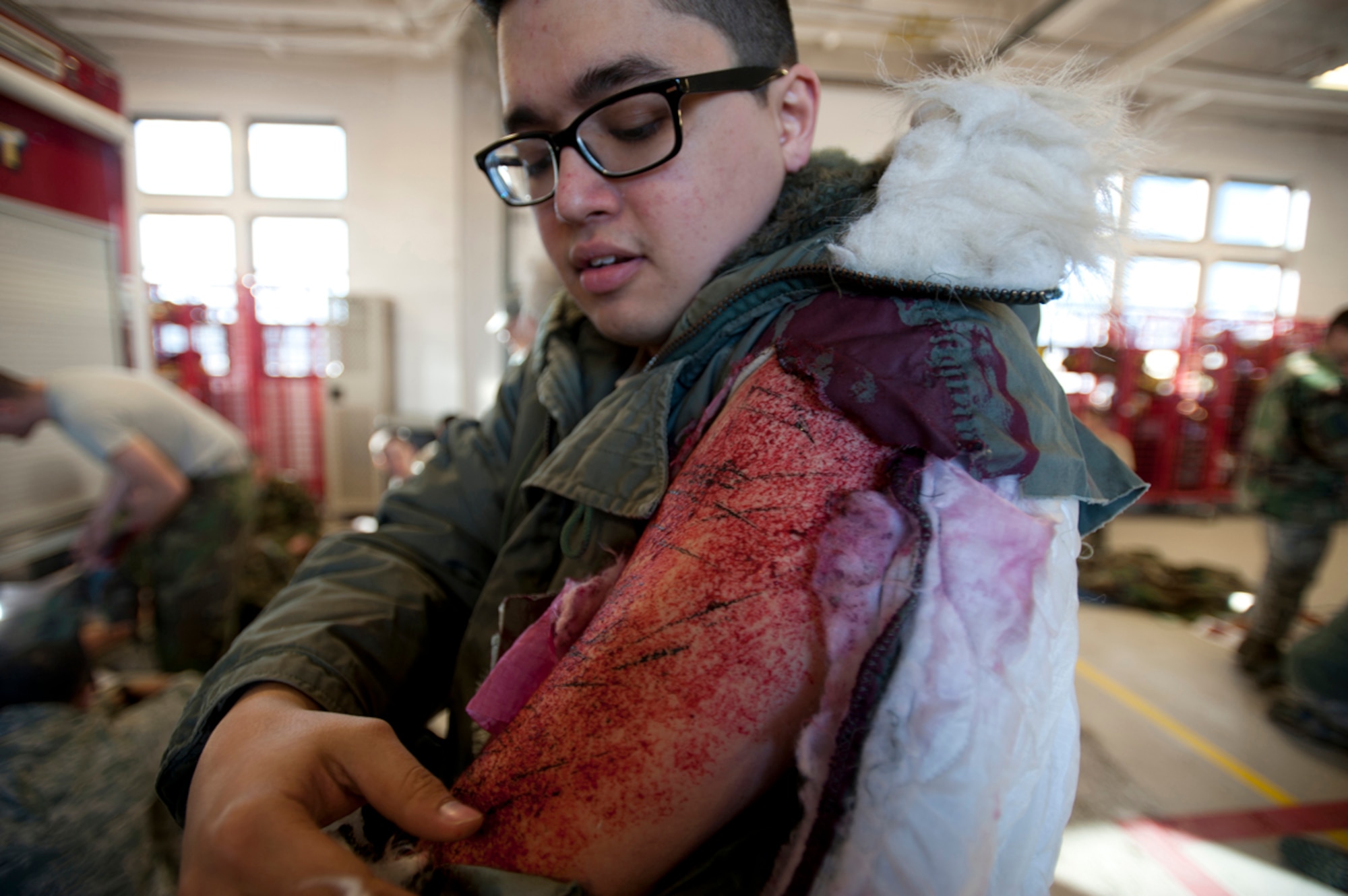 Senior Airman Scott Ellis examines his simulated wound after a simulated earthquake emergency scenario on Joint Base Elmendorf-Richardson, Alaska, March 27, 2014. The Mission Assurance Exercise 14-3 is part of the overall Alaska Shield disaster response preparedness and response exercise. MAE 14-3 is one of many exercises for Alaska Shield. AK Shield is a statewide exercise that tests local, state and federal cooperation at multiple venues throughout the state. (U.S. Air Force photo/Staff Sgt. Robert Barnett)
