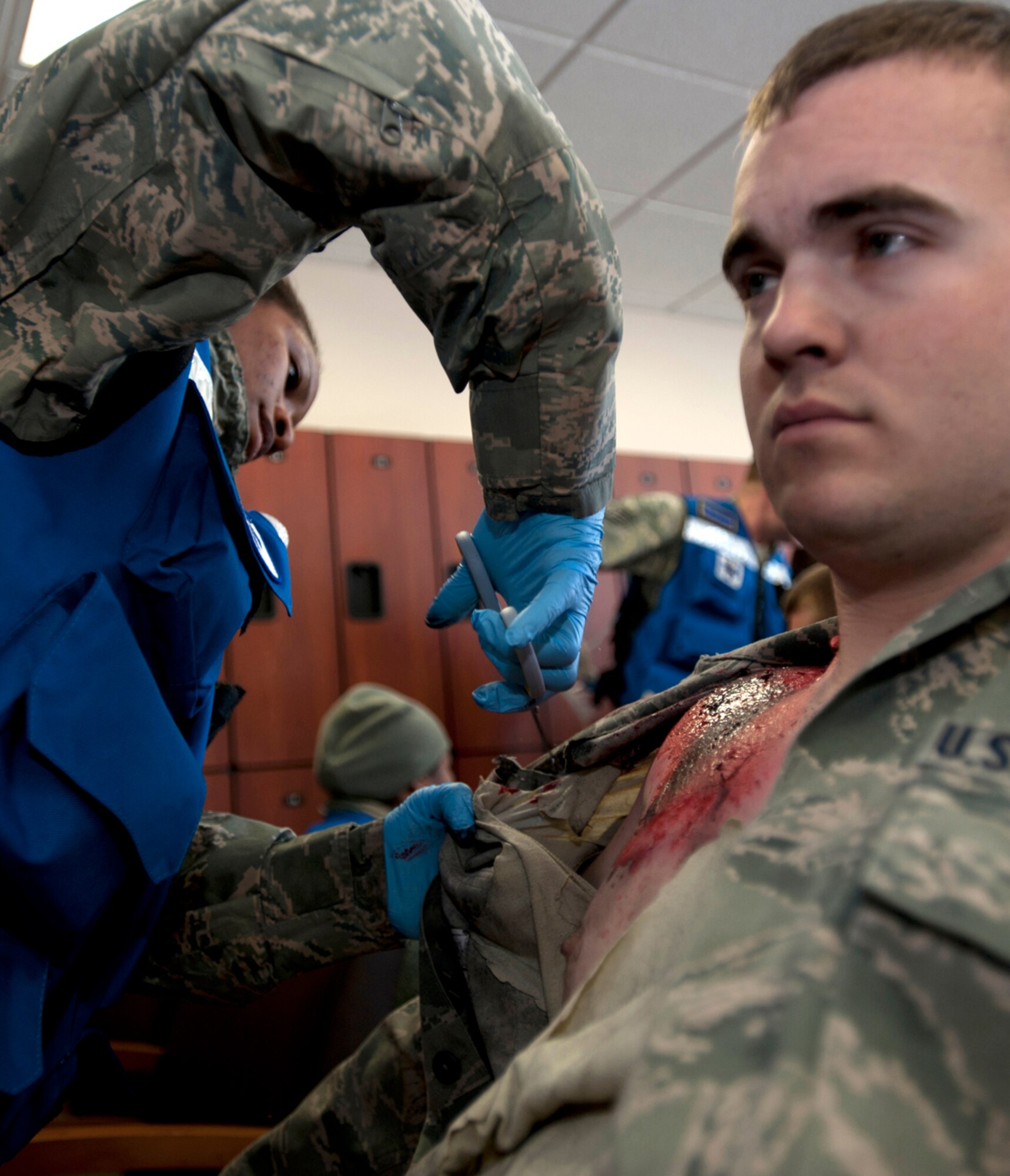 Tech. Sgt. Alexis Lewis cuts uniform material away from Senior Airman Taylor Brown's simulated chest burns after an simulated earthquake during Joint Base Elmendorf-Richardson's Mission Assurance Exercise 14-3, part of the overall Alaska Shield disaster response preparedness and response exercise March 27, 2014. Lewis is 673d Medical Group independent duty medical technician. Brown is 673d Communications Squadron radio frequency technician. (U.S. Air Force photo/Staff Sgt. Robert Barnett)