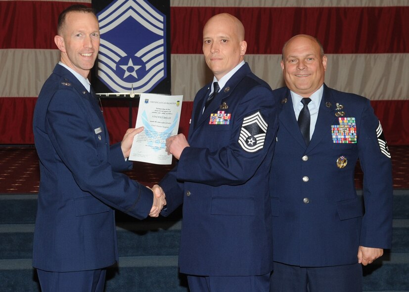Chief Master Sgt. Vincent Miller, 2nd Maintenance Squadron, receives a certificate of promotion from Col. Leland Bohannon, 2nd Bomb Wing vice commander, and Chief Master Sgt. Stephen Lebrun, 2nd Operations Group, during the January Wing Promotion Ceremony on Barksdale Air Force Base, La., Jan. 31, 2014. (U.S. Air Force photo)