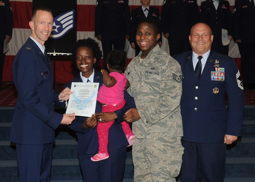 Staff Sgt. Keona Woods, 2nd Operations Support Squadron, receives a certificate of promotion from Col. Leland Bohannon, 2nd Bomb Wing vice commander, and Chief Master Sgt. Stephen Lebrun, 2nd Operations Group, during the January Wing Promotion Ceremony on Barksdale Air Force Base, La., Jan. 31, 2014. (U.S. Air Force photo)
