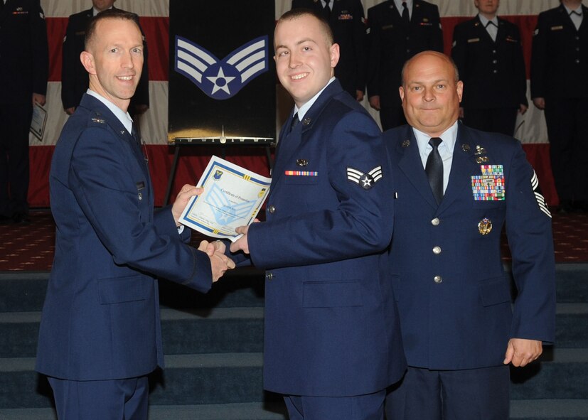 Senior Airman Justin May, 2nd Maintenance Squadron, receives a certificate of promotion from Col. Leland Bohannon, 2nd Bomb Wing vice commander, and Chief Master Sgt. Stephen Lebrun, 2nd Operations Group, during the January Wing Promotion Ceremony on Barksdale Air Force Base, La., Jan. 31, 2014. (U.S. Air Force photo)