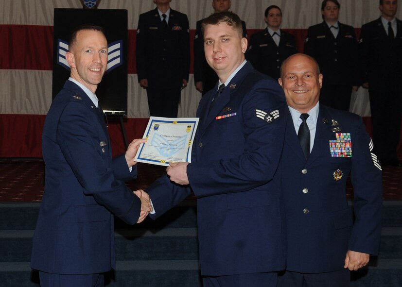 Senior Airman Wendell Brown, 2nd Maintenance Squadron, receives a certificate of promotion from Col. Leland Bohannon, 2nd Bomb Wing vice commander, and Chief Master Sgt. Stephen Lebrun, 2nd Operations Group, during the January Wing Promotion Ceremony on Barksdale Air Force Base, La., Jan. 31, 2014. (U.S. Air Force photo)