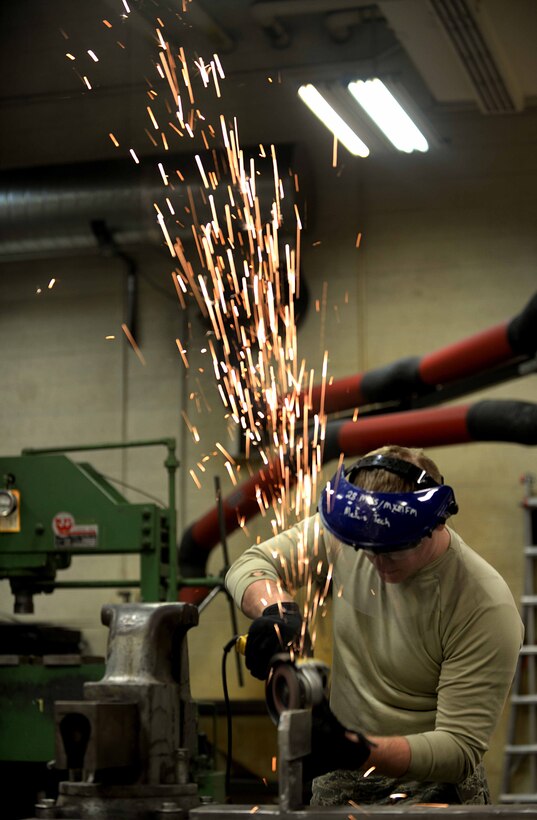 Airman 1st Class Drake Anderson, 28th Maintenance Squadron metals technician, grinds an egress seat fixture in the Metals Shop at Ellsworth Air Force Base, S.D., March 25, 2014. Metals technology technicians are part of the 28th MXS that is responsible for all off-equipment maintenance and heavy repairs, maintaining more than 660 pieces of aerospace ground equipment and supporting 27 B-1 bombers assigned to the 28th Bomb Wing. (U.S. Air Force photo by Airman 1st Class Rebecca Imwalle/Released)