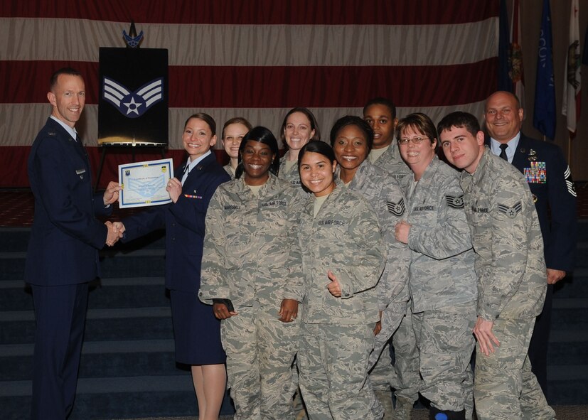 Senior Airman Jennifer Mancini, 2nd Aerospace Medicine Squadron, receives a certificate of promotion from Col. Leland Bohannon, 2nd Bomb Wing vice commander, and Chief Master Sgt. Stephen Lebrun, 2nd Operations Group, during the January Wing Promotion Ceremony on Barksdale Air Force Base, La., Jan. 31, 2014. (U.S. Air Force photo)