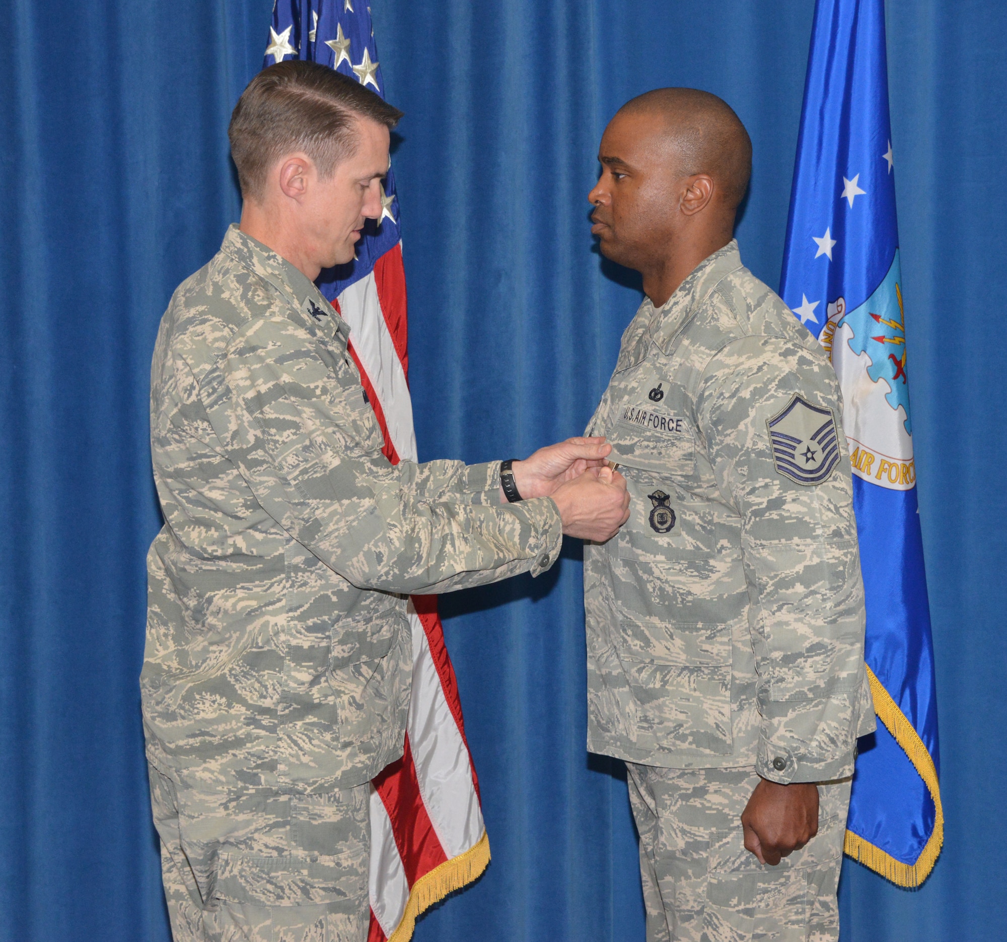 Col. Tom Miller (left), 377th Air Base Wing commander, pins a Bronze Star Medal on Master Sgt. Antoine Washington, 377th Security Forces Squadron, at a ceremony March 27 in the Wing Presentation Center at Kirtland. (Photo by Dennis Carlson)