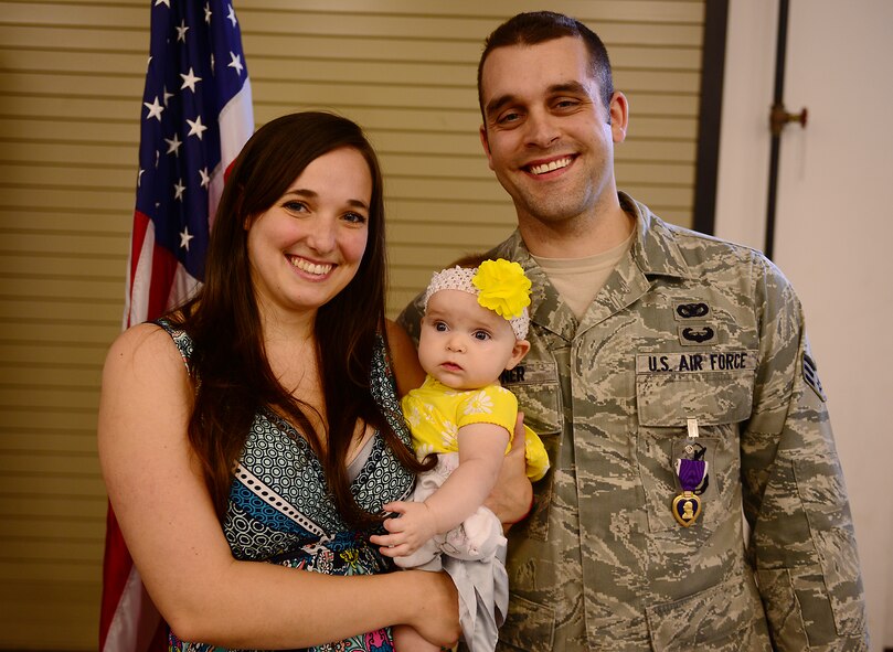 U.S. Air Force Senior Airman Michael Haffner, 822d Base Defense Squadron fire team member, stands with wife Lisa and daughter Ruthie after receiving a Purple Heart at Moody Air Force Base, Ga., March 27, 2014. Haffner received the medal for his efforts and combat injuries sustained while deployed to Bagram Airfield, Afghanistan in May 2013, during Lisa’s pregnancy with Ruthie. (U.S. Air Force photo by Senior Airman Tiffany M. Grigg/Released) 