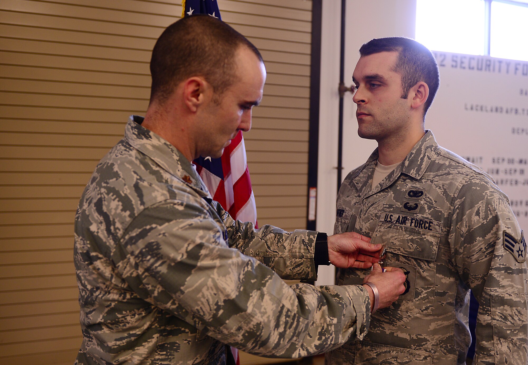 U.S. Air Force Senior Airman Michael Haffner, 822d Base Defense Squadron fire team member (right), receives a Purple Heart from Maj. Christopher Hagemeyer, 822d BDS commander, at Moody Air Force Base, Ga., March 27, 2014. Haffner is one of five 822d BDS Airmen to receive a Purple Heart for injuries sustained in a combat zone since the squadron’s activation in May 1997. (U.S. Air Force photo by Senior Airman Tiffany M. Grigg/Released) 