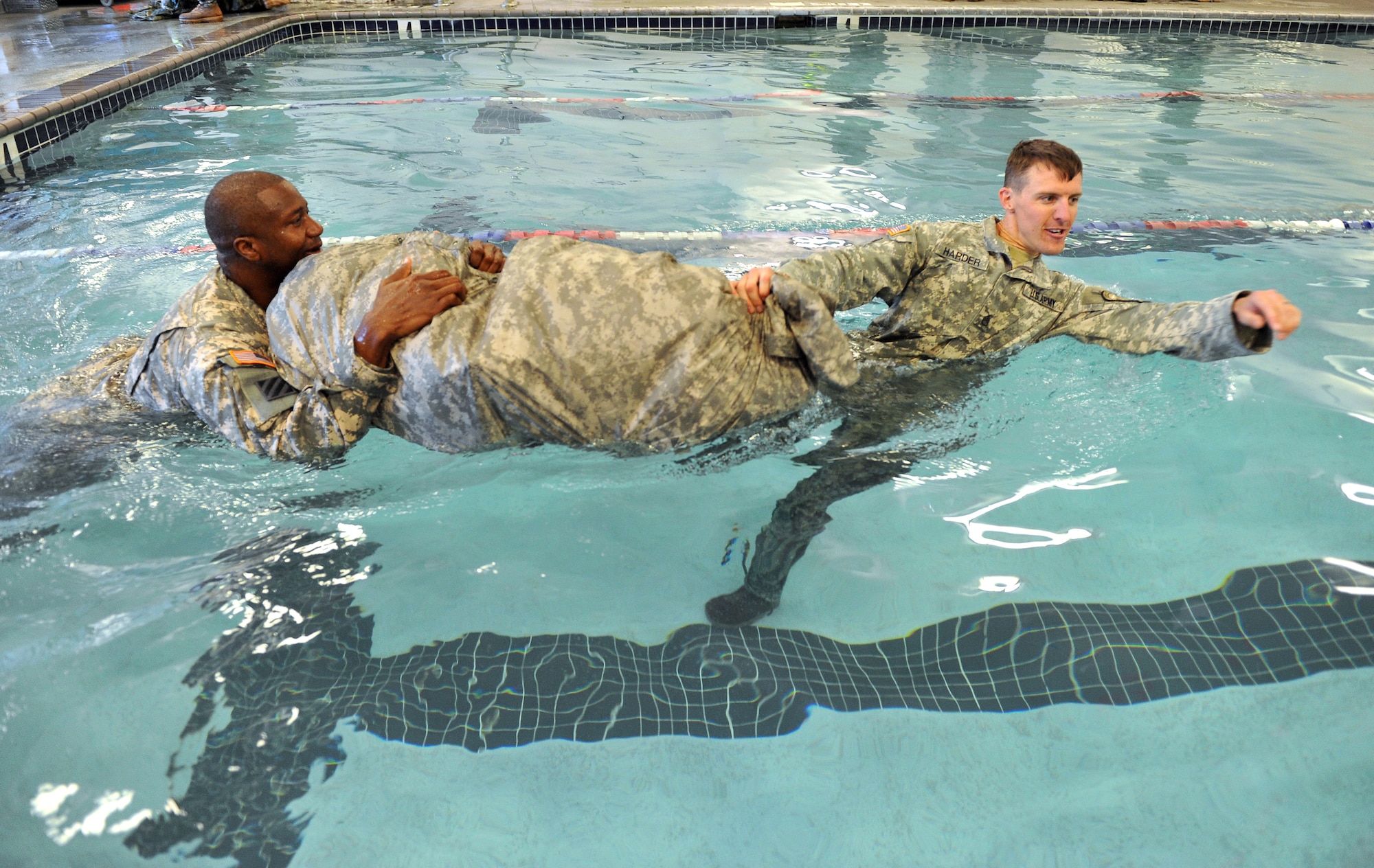 Sergeant 1st Class George Simms (left) and Staff Sgt. Eric Harder (right), Airborne Target Surveillance supervisors, use a poncho raft to move through the pool at the base fitness center on March 14. (U.S. Air Force photo by Tommie Horton)