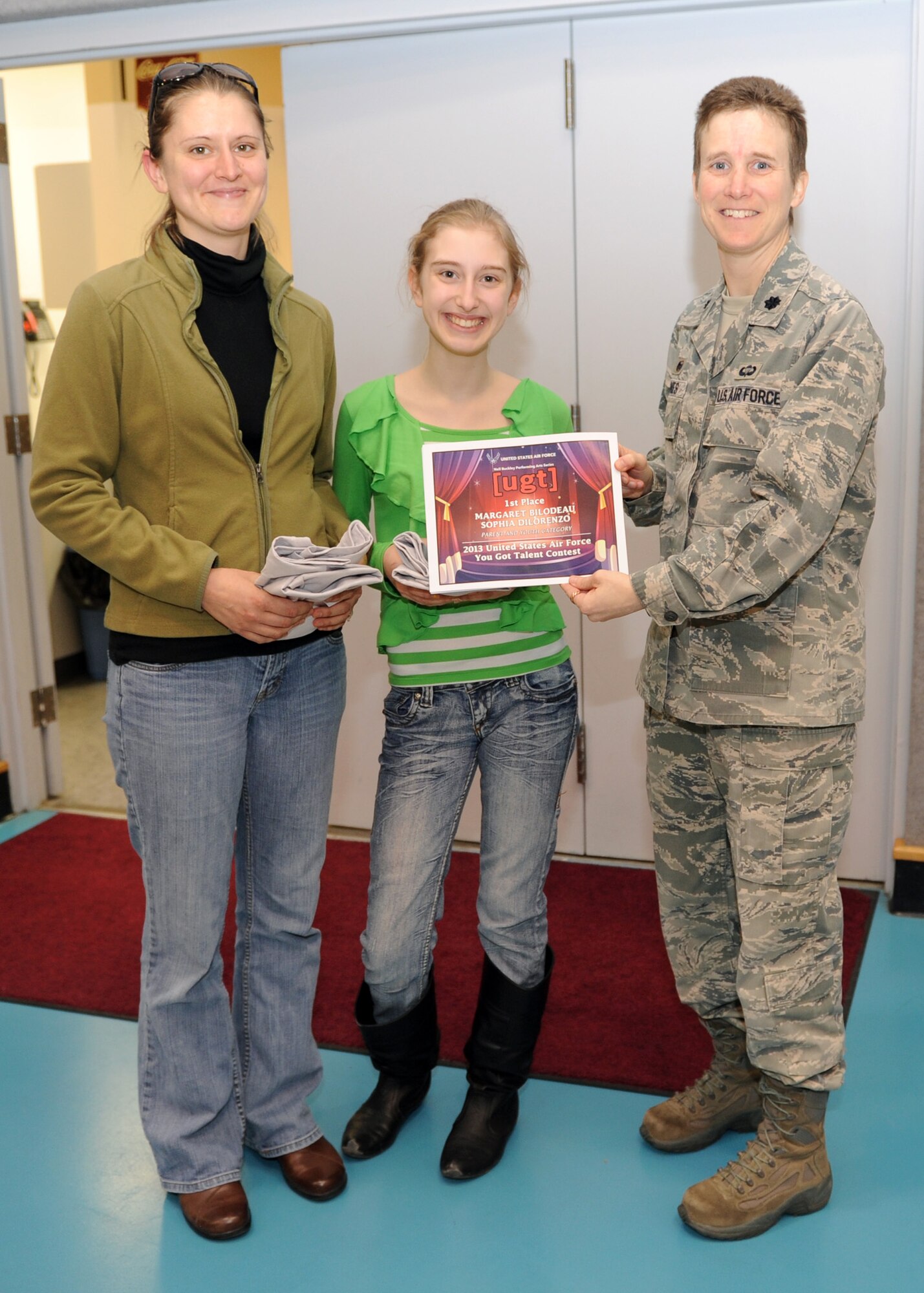 Margaret Bilodeau and her daughter Sophia DiLorenzo receive a certificate from Lt. Col. Sabrina Jones, 341st Force Support Squadron commander, after placing first in the Air Force-level You Got Talent competition for their singing duet of “Traveling Soldier” by the Dixie Chicks. The goal of the UGT contest is to develop creative expression and appreciation of the arts in the participants, provide an opportunity for families to participate together in a program and acknowledge the best talent in the Air Force. (U.S. Air Force photo/Senior Airman Katrina Heikkinen)