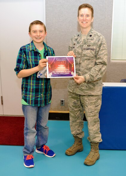 Zion Buchi receives a certificate from Lt. Col. Sabrina Jones, 341st Force Support Squadron commander, after  placing second in the Air Force-level You Got Talent competition for his piano solo of “Argentina” by Catherine Rollin. The UGT contest is an annual Air Force event open to all Air Force family members, including the spouses of Airmen and their children ages 3 to 18 years old. (U.S. Air Force photo/Senior Airman Katrina Heikkinen) 