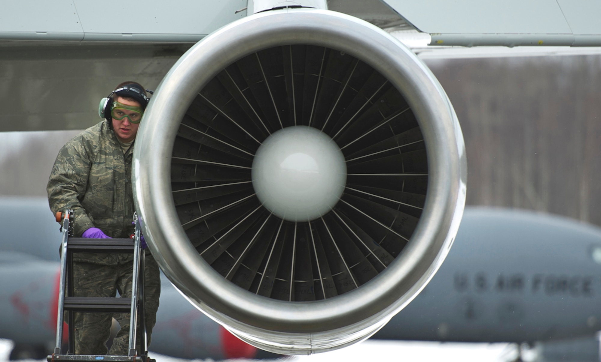 Senior Airman Kody Medrek, assigned to the 962nd Aircraft Maintenance Unit, checks an engine while performing maintenance on a E-3 Sentry Airborne Warning and Control System aircraft after a mission on Joint Base Elmendorf-Richardson, Alaska, Wednesday, March 17, 2014. (U.S. Air Force photo by Justin Connaher/Released)