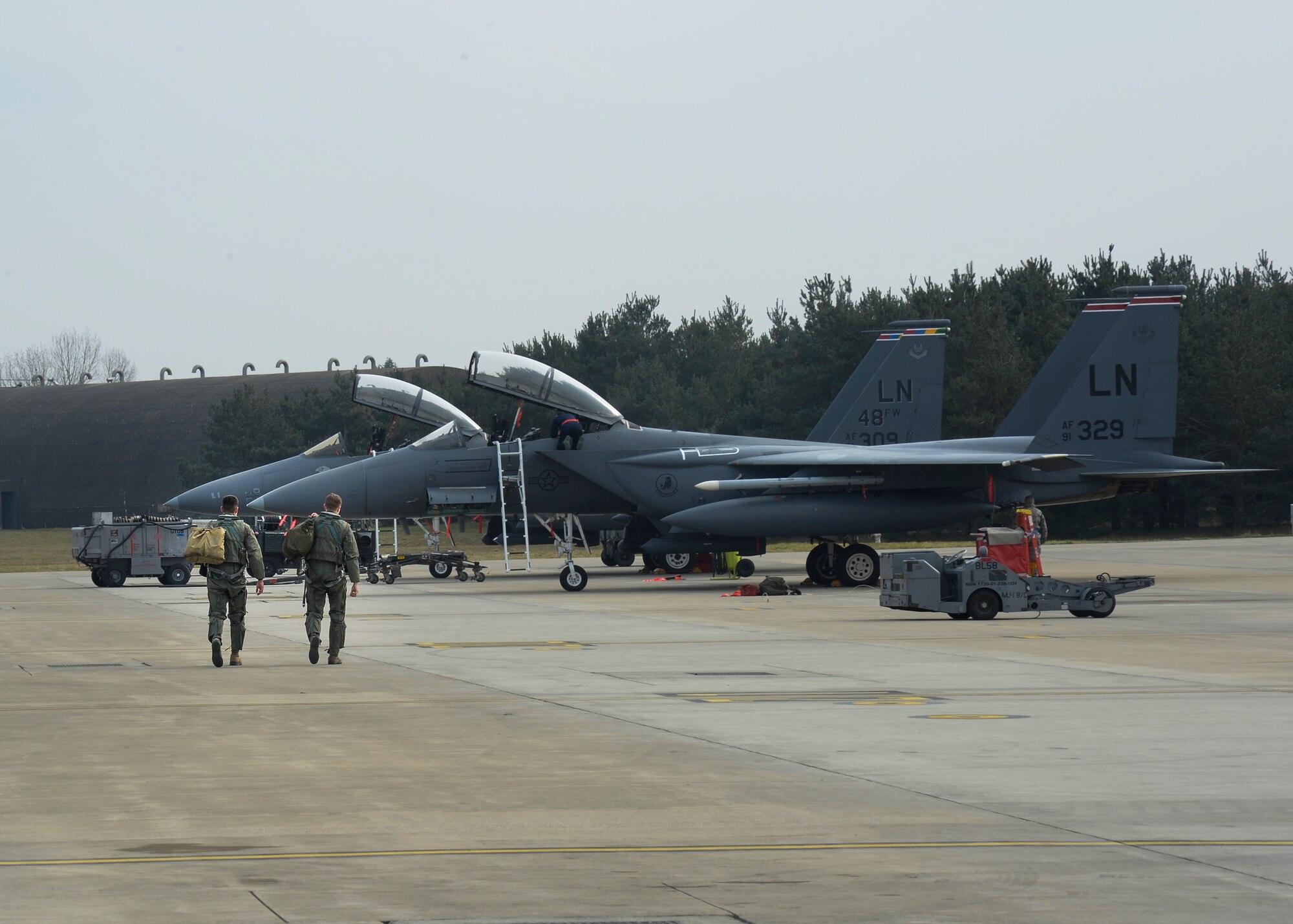 A pilot and weapons systems officer from the 494th Fighter Squadron approach an F-15E Strike Eagle they will fly on the flightline at Royal Air Force Lakenheath, England, March, 28, 2014. The 494th FS is participating in Exercise Tonnerre Lightning, which  is a series of training aimed at improving interoperability between the partner-nation air forces of the United Kingdom, France, and the United States. (U.S. Air Force photo by Airman 1st Class Nigel Sandridge/Released)