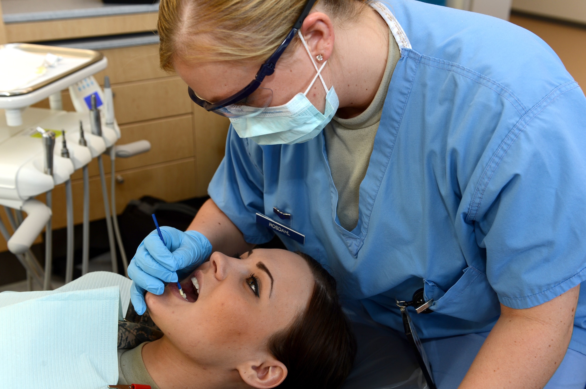 U.S. Air Force Airman 1st Class Alicia Rosdahl, 52nd Dental Squadron dental technician from Greenville, N.C., paints a fluoride treatment on the teeth of U.S. Air Force Senior Airman Victoria Perrone, 52nd DS dental technician from Chandler, Ariz., at Spangdahlem Air Base, Germany, March 28, 2014. Fluoride is used to help prevent tooth decay by protecting the teeth from bacteria in plaque. (U.S. Air Force photo by Airman 1st Class Kyle Gese/Released)