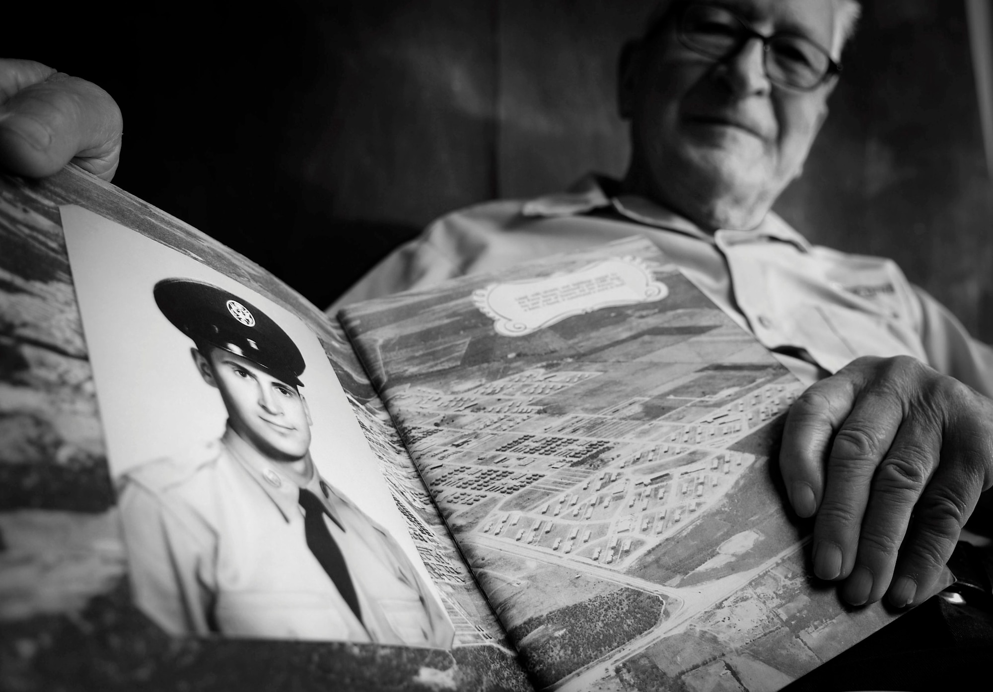 Peter Karpawitz-Godt, Kaiserslautern Military Community clothing issue military management clerk, looks at his Basic Military Training photograph and reminisces about the past March, 18, 2014, at Ramstein Air Base, Germany. Karpawitz-Godt was born and raised in Germany until his father’s friends sponsored him to America to go to school. (U.S. Air Force photo/Airman Dymekre Allen)