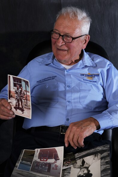Peter Karpawitz-Godt, Kaiserslautern Military Community clothing issue military management clerk, shows off a photo of himself from his time in the Air Force March 18, 2014, at Ramstein Air Base, Germany. Karpawitz-Godt, was 27 years old when he joined the Air Force but had been introduced to the military at a young age. Karpawitz-Godt has given more than 50 years of his life to the U.S. military.  (U.S. Air Force photo/Airman Dymekre Allen)