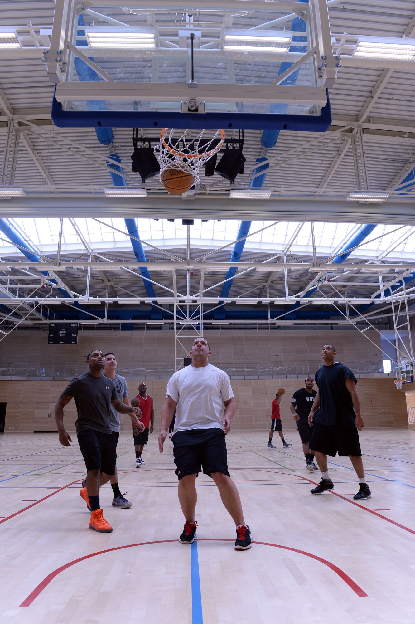 Players watch as the basketball swishes through the net during a First IV-sponsored March Madness basketball tournament at the Eifel Powerhaus at Spangdahlem Air Base, Germany, March 27, 2014. The single-elimination tournament ended with “The Bomb Squad” taking the prize.  (U.S. Air Force photo by Senior Airman Alexis Siekert/Released)