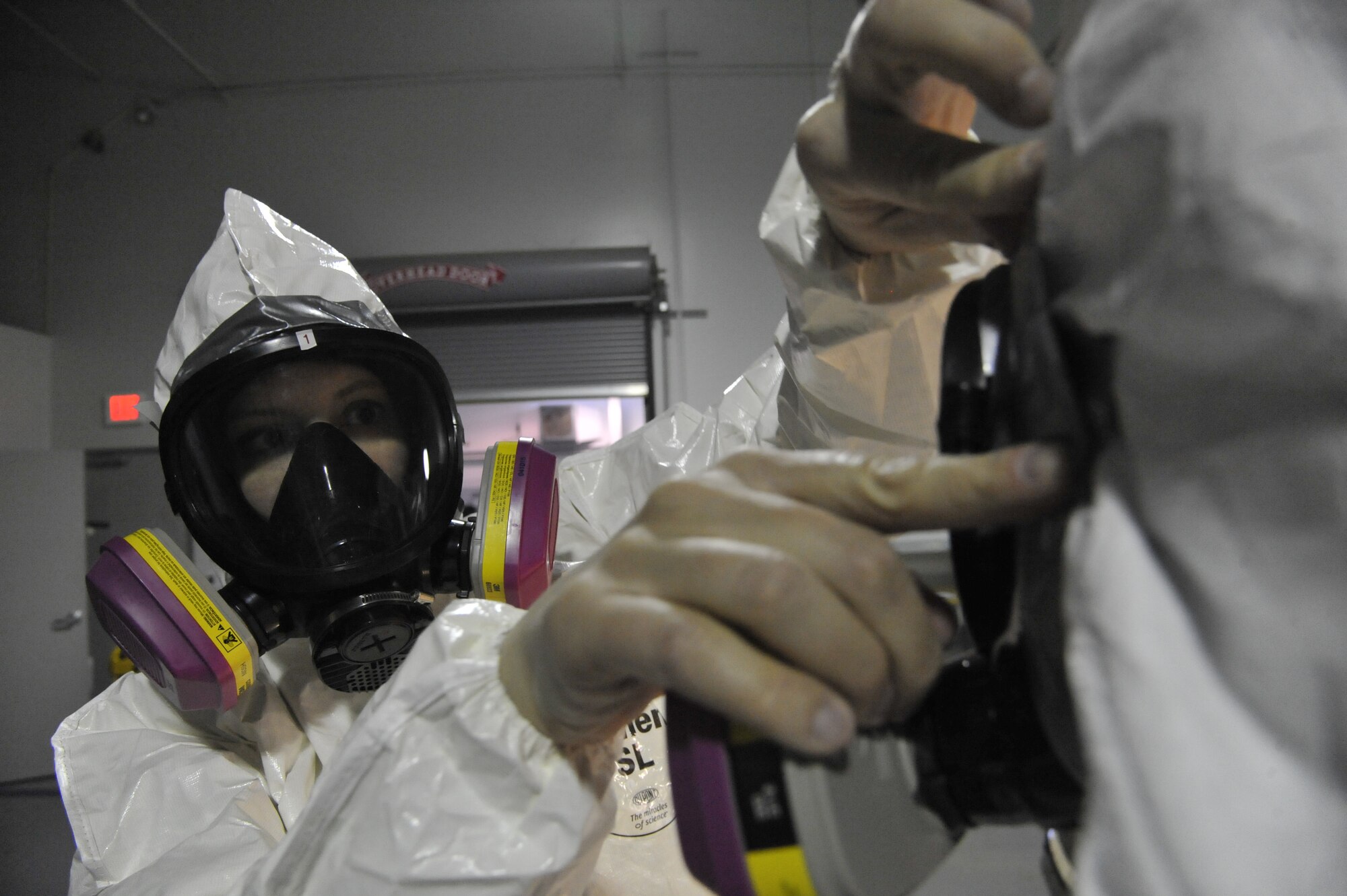 U.S. Air Force Tech. Sgt. Annemieke LeBorgne, 509th Medical Operations Squadron NCO in charge of Occupational Health, tapes the respirator for Staff Sgt. Tyler Haugland, 509th Medical Operations Squadron bioenvironmental readiness and radiation program manager, at Whiteman Air Force Base, Mo., March 12, 2014. The tape is used to seal any holes or cracks to prevent exposure to chemicals or radiation. (U.S. Air Force photo by Airman 1st Class Keenan Berry/Released)