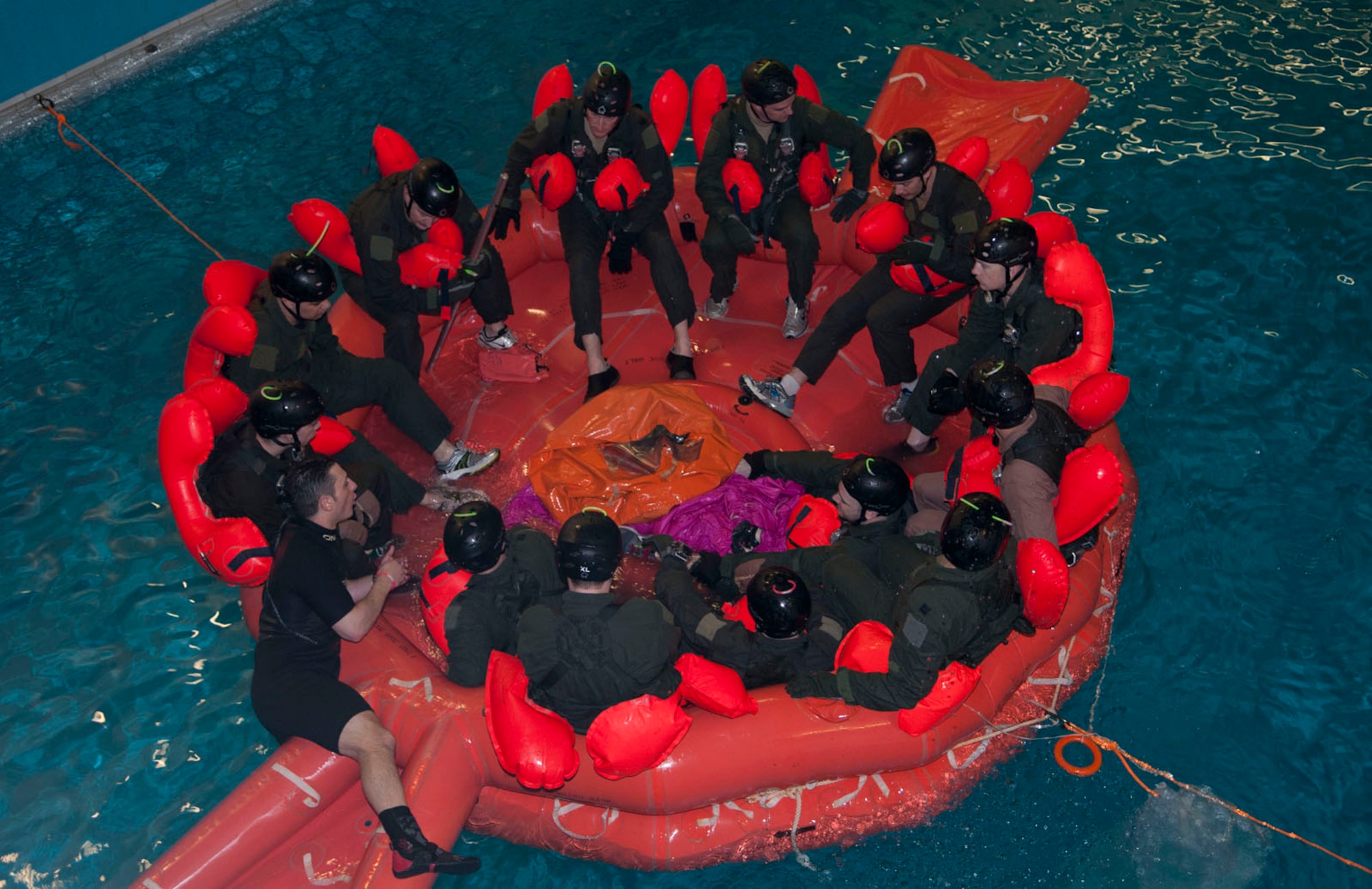 An RAF Mildenhall Survival, Evasion, Resistance and Escape specialist debriefs aircrew after an exercise simulating severe storm conditions similar to a rough North Sea during water survival training March 20, 2014, at Lowestoft College in Norfolk, England. The training also included parachute disentanglement and drags and simulated helicopter hoists. (U.S. Air Force photo by Karen Abeyasekere/Released)