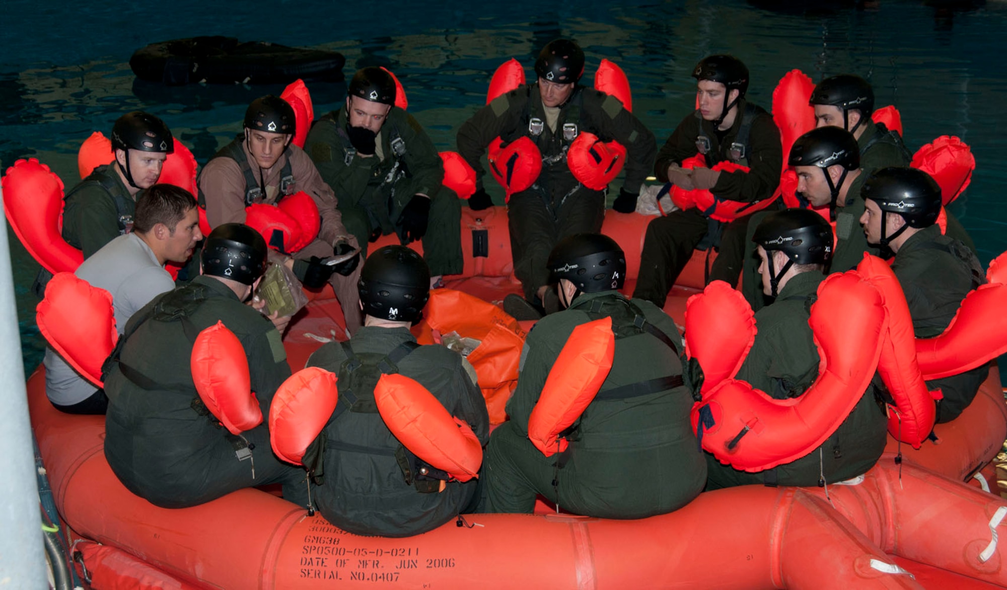U.S. Air Force Staff Sgt. Jonathon Schmitz, left, 100th Operations Support Squadron Survival, Evasion, Resistance and Escape specialist and NCO in charge of SERE operations from Minneapolis, gives aircrew instructions on 20-man survival-raft techniques and living considerations during water survival training March 20, 2014, at Lowestoft College in Norfolk, England. According to Schmitz, hands-on refresher WST involves physically familiarizing individuals with operational use of equipment in less-than-ideal conditions, to give aircrew the confidence and experience to use their equipment as well as to assist others to survive in isolating circumstances. (U.S. Air Force photo by Karen Abeyasekere/Released)