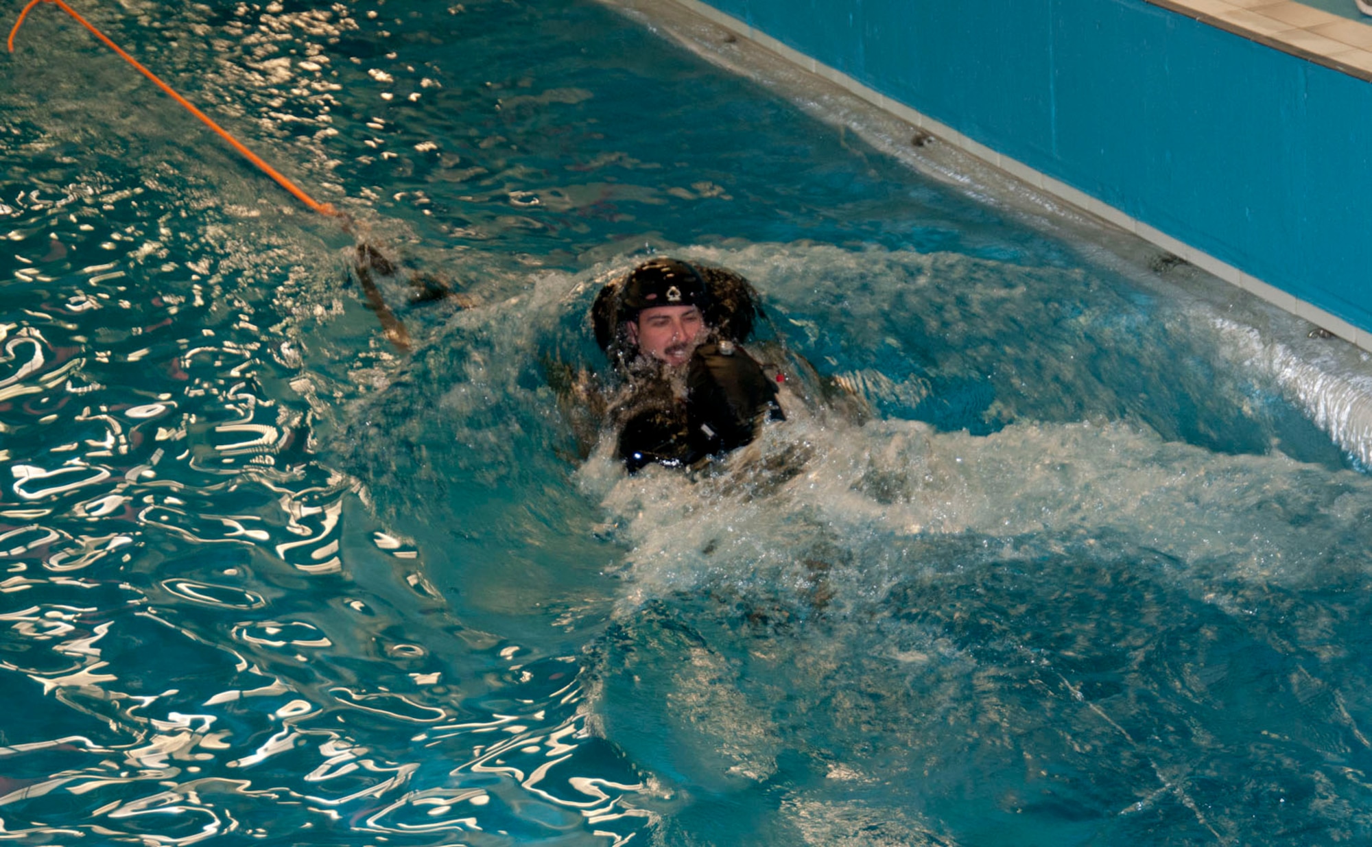U.S. Air Force 1st Lt. Zachary Zimmerman, 494th Fighter Squadron, RAF Lakenheath, weapons systems operator from Scottsdale, Ariz., assumes the position for a parachute drag simulation as part of water survival training March 20, 2014, at Lowestoft College in Norfolk, England. During the scenario, a team of fellow aircrew, standing on the opposite edge of the pool, pull the rope and drag the person in the water backwards. (U.S. Air Force photo by Karen Abeyasekere/Released)