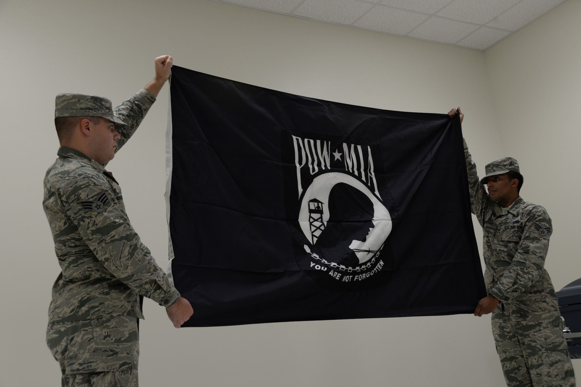 U.S. Air Force Senior Airmen John McCloskey and Diego Moreno, 20th Force Support Squadron honor guardsmen, present the POW/MIA flag during morning formation in their new building, Shaw Air Force Base, S.C., March 25, 2014. Their new building has more space for indoor practice allowing them to better perform.  (U.S. Air Force photo by Airman 1st Class Michael A. Cossaboom/Released)