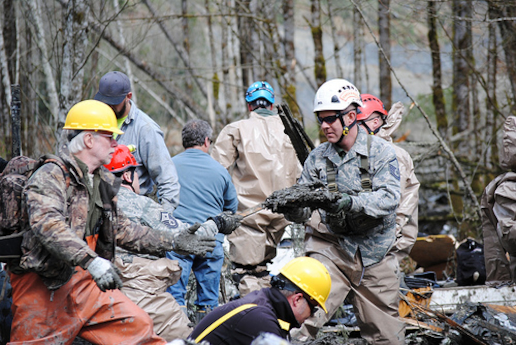 Washington Air National Guardsmen methodically make their way through the mud and wreckage left behind by Saturday's mudslide in Oso, Wash. More than 70 guardsmen have been activated to support the search and rescue efforts. (Photo by Spc. Matthew Sissel, 122D PAOC)