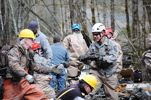 Washington Air National Guardsmen methodically make their way through the mud and wreckage left behind by Saturday's mudslide in Oso, Wash. More than 70 guardsmen have been activated to support the search and rescue efforts. (Photo by Spc. Matthew Sissel, 122D PAOC)